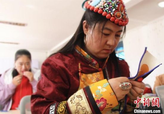 圖為裕固族婦女學(xué)習(xí)刺繡?！∈缝o靜 攝