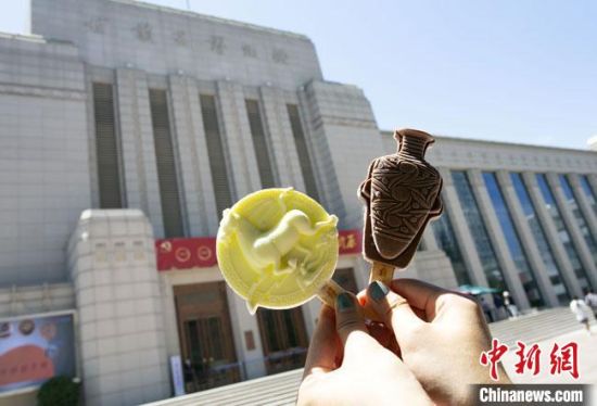2021年7月30日,游客手拿“銅奔馬”“彩陶瓶”造型的雪糕,在甘肅省博物館前拍照打卡。 高展 攝 2021年7月30日,游客手拿“銅奔馬”“彩陶瓶”造型的雪糕,在甘肅省博物館前拍照打卡。 高展 攝