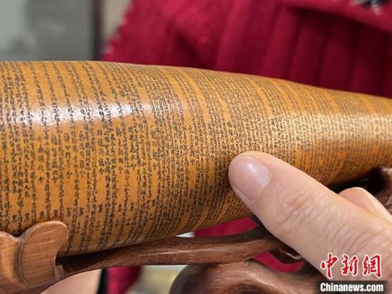 圖為長約二十公分的長條葫蘆雕刻佛教經文作品?！堟?攝