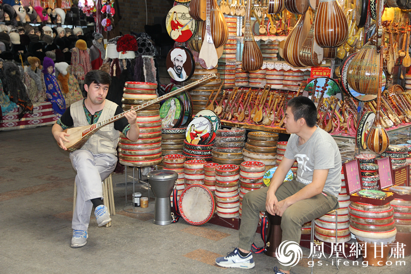 烏魯木齊二道橋巴扎內，店主正在向客人展示樂器。楊文遠 攝