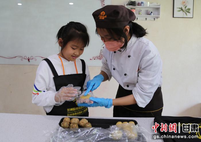 圖為在甘臺胞小朋友在工作人員指導下制作月餅。九美旦增 攝 圖為在甘臺胞小朋友在工作人員指導下制作月餅。九美旦增 攝