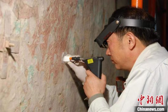敦煌研究院研究員樊再軒進行壁畫修復。(資料圖)張云文 攝 敦煌研究院研究員樊再軒進行壁畫修復。(資料圖)張云文 攝